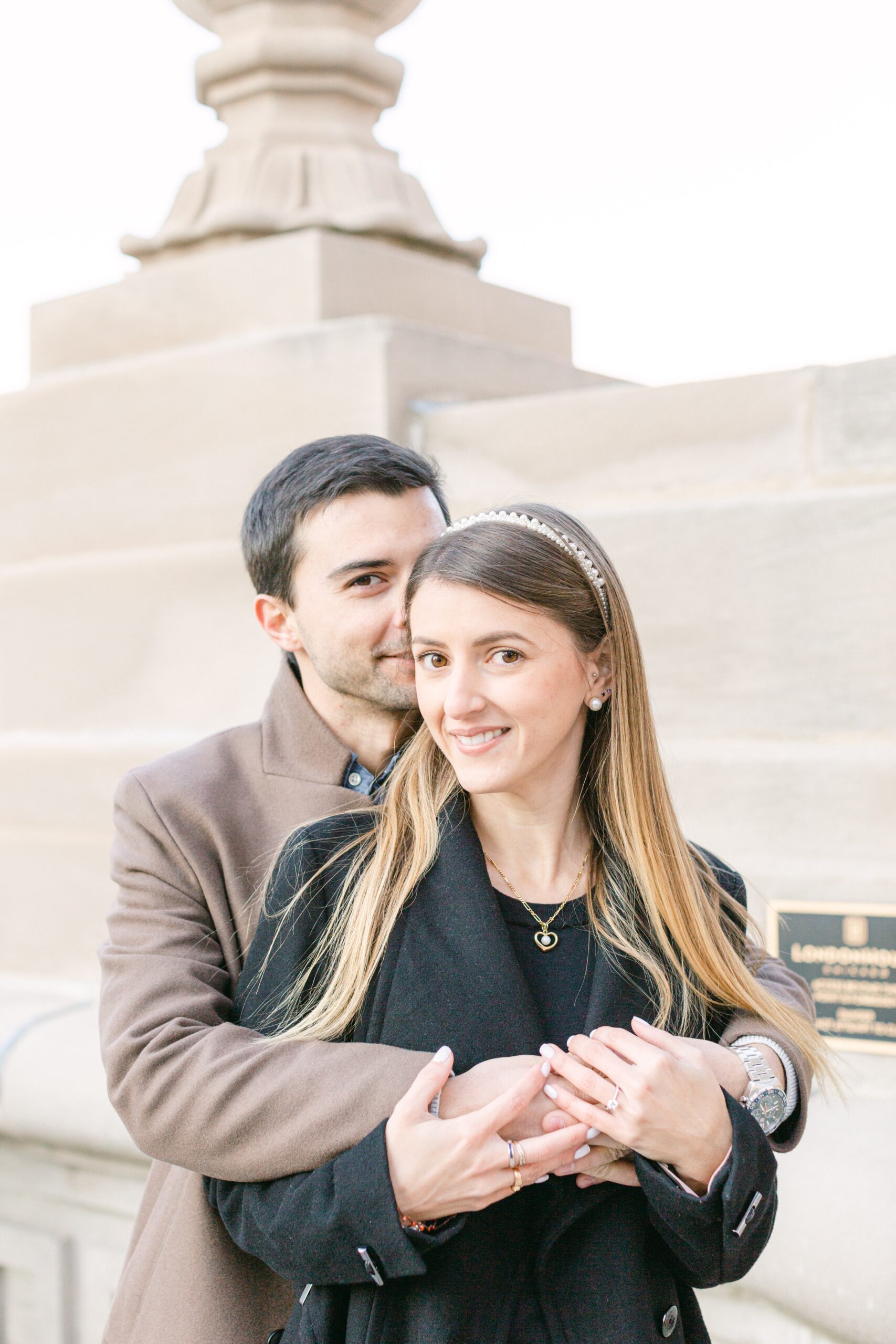 A beautiful couple, posing after a proposal above a skyscraper