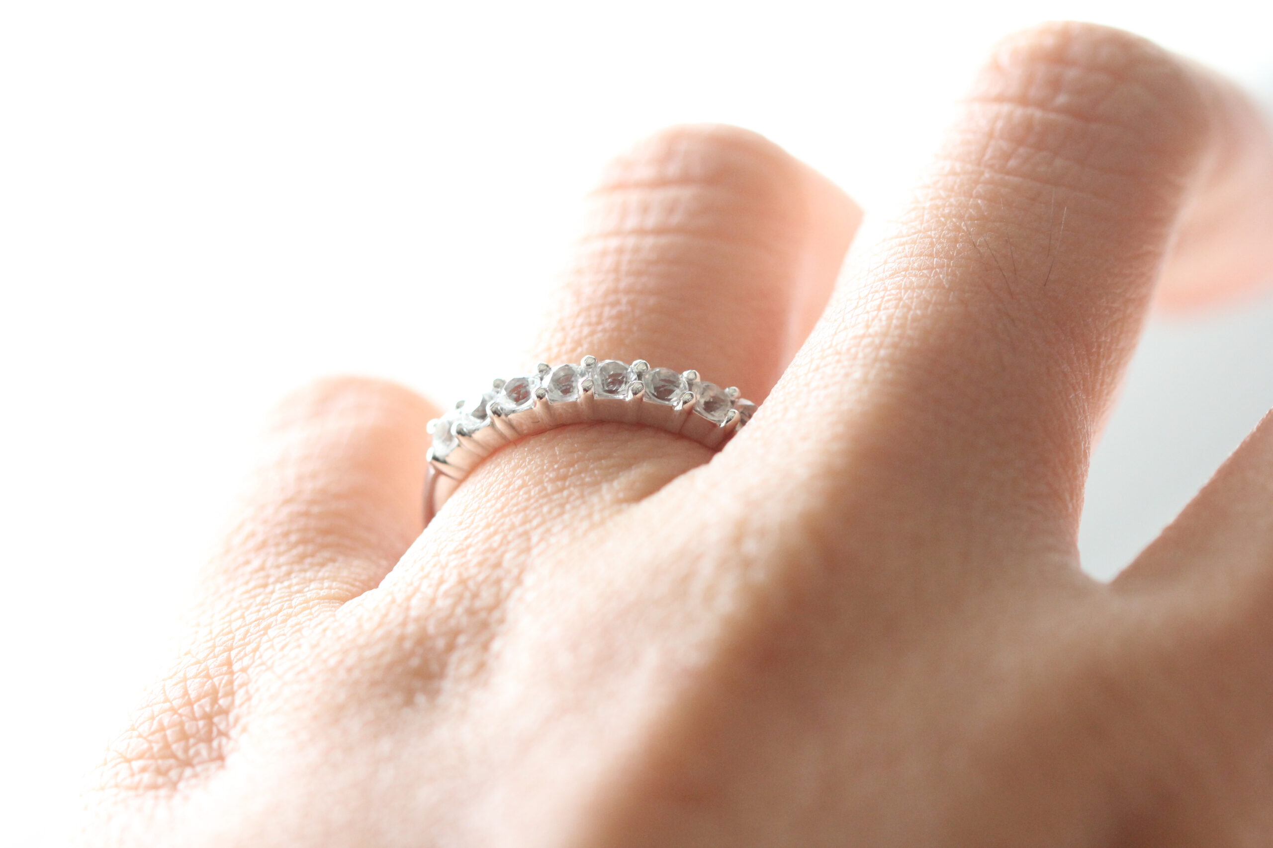A halfway diamond ring, displayed by a lady on her ring finger. Shop diamond anniversary rings here.