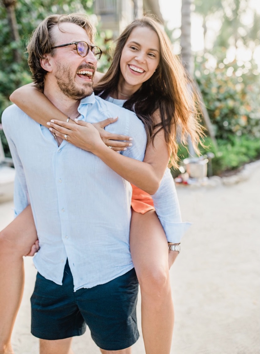 A beautiful couple, woman riding piggy-back on man, after he proposed to her