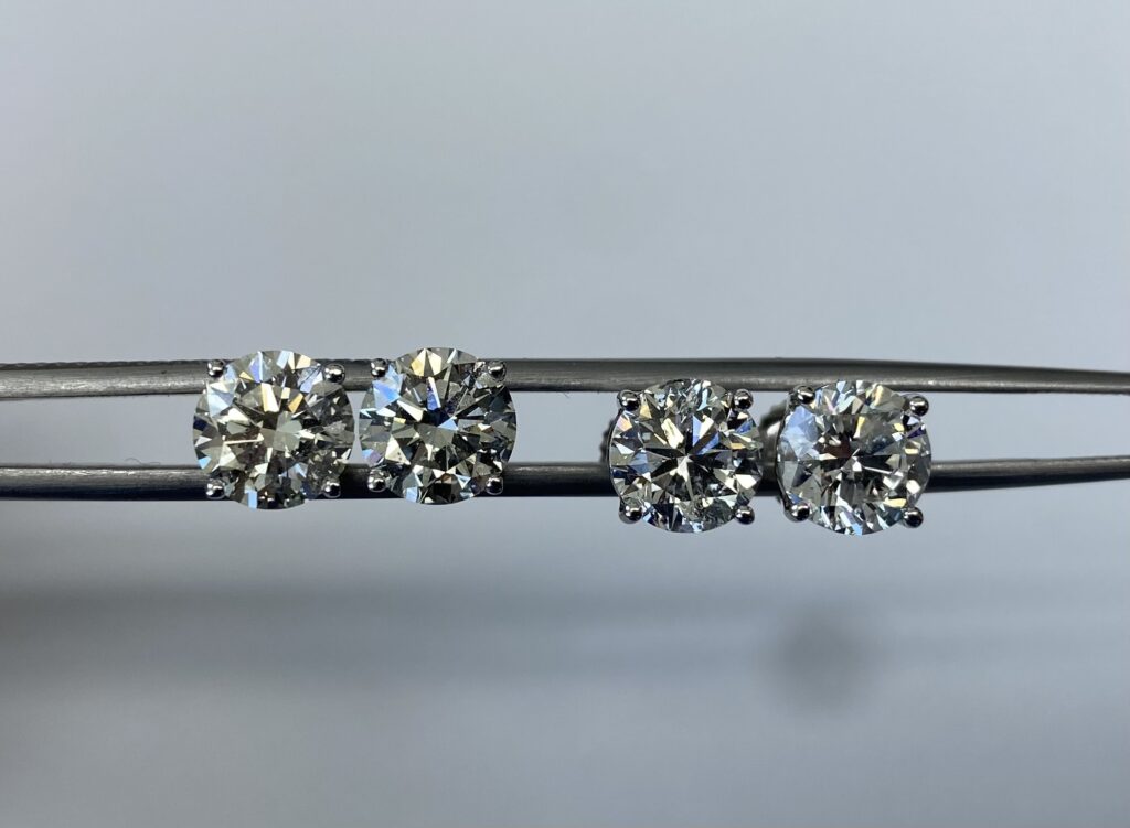 Lab grown pair of round brilliant diamond studs versus natural pair, both totaling around 3 carats